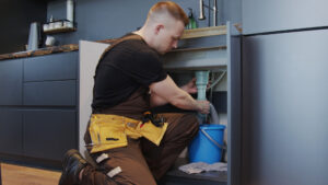 Plumber in Cape Coral, FL fixing a residential sink leak in a kitchen